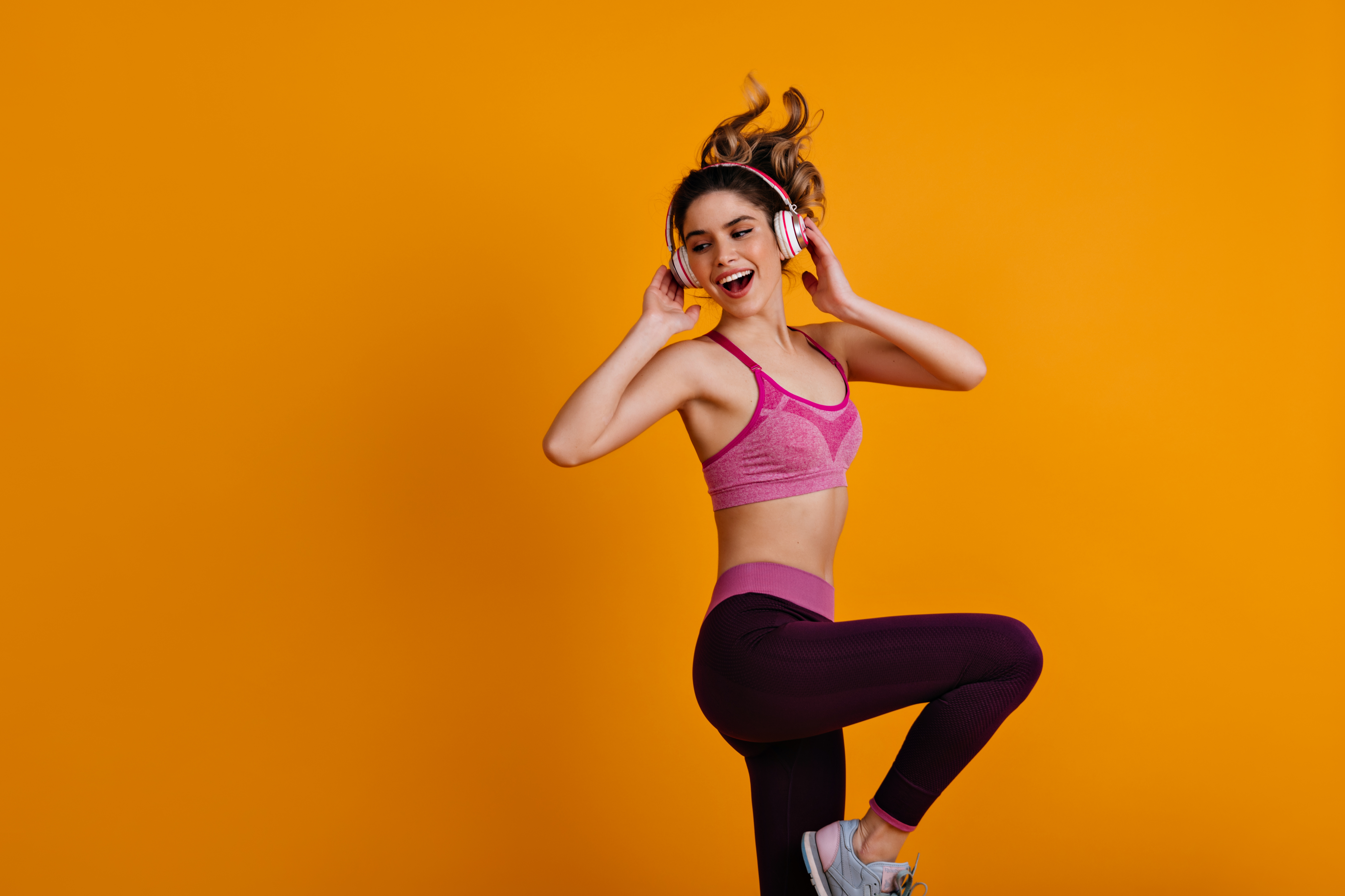 Happy white girl enjoying zumba. Indoor photo of dancing fitness woman